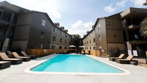 A swimming pool surrounded by lounge chairs and a building with balconies. - Boulevard Stays Relaxed 1BR King Suite Near Downtown, Pool & Gym Access (Austin)