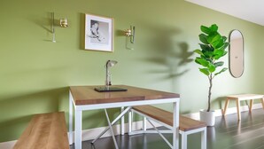 A modern room with a wooden table, bench, and a potted plant. - Boulevard Stays Relaxed 1BR King Suite Near Downtown, Pool & Gym Access (Austin)