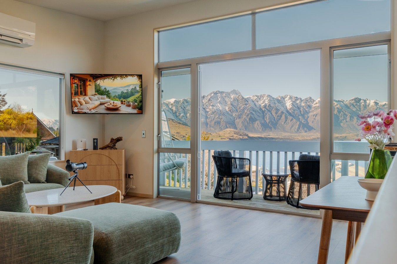 A spacious room with a large window overlooking a mountainous landscape.