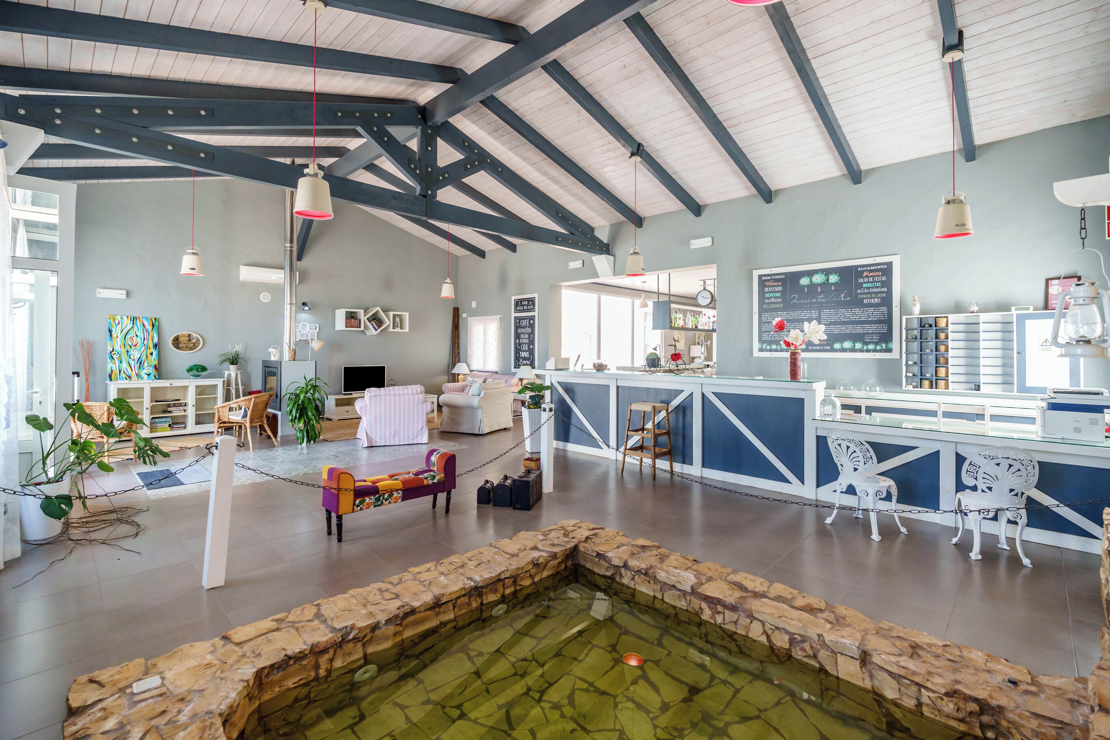 A spacious room with a stone fountain, a bar area, and seating.
