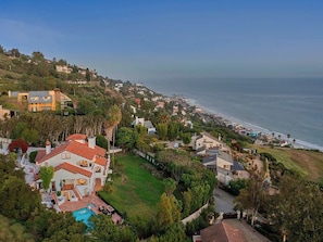 Un quartier résidentiel en bord de mer, avec des maisons, une piscine et une vue sur l’océan.