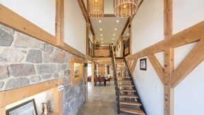 Un escalier en bois, avec un mur en pierre d’un côté et une structure en poutres de bois de l’autre.