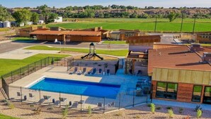 Ein modernes Gebäude mit Schwimmbad, Außenbereich und Spielplatz.