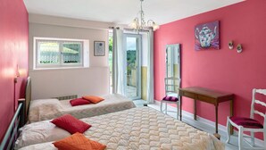 A bedroom with two beds, a window, a table, and a chair. - Gîte Charly: Private Terrace, Shared Garden, Pool & Wi-Fi in Salignac Eyvigues (Salignac Eyvigues)