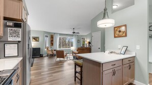 A modern kitchen with wooden cabinets, a white countertop, and a built-in island. - Hansen Park Place (New Brighton)