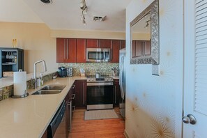 Una cocina moderna con armarios de madera, electrodomésticos de acero inoxidable y un salpicadero de azulejos.