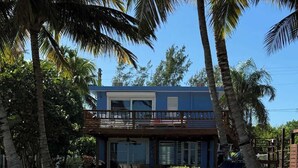 A two-story house with a pool and palm trees. - Beachfront, Spacious Home, Private Luxury Pool! (Palmer)