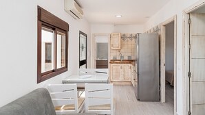 Una cocina compacta con refrigerador, armarios de madera y una ventana.