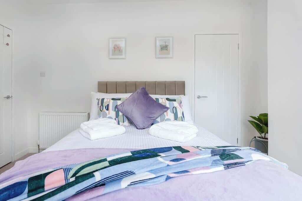 A neatly made bed with a patterned bedspread, a headboard, and two pillows.