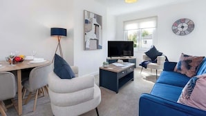 A modern living room with a TV, sofa, and dining area. - Fraser Apartment- 2 Bedrooms Inverleith, Edinburgh (Edinburgh)