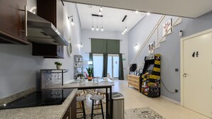 Une cuisine moderne dotée d’un îlot central, de tabourets de bar et d’une poubelle.