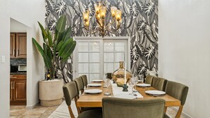 A dining area with a table set for four, a chandelier, and a large plant. - Scottsdale Luxury Villa w/ Pool, Hot Tub, Pickleball, Mini-Golf, Basketball (Scottsdale)