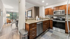 A modern kitchen with wooden cabinets, stainless steel appliances, and a granite countertop. - Eagle River Retreat I Hot tub & Pool (Avon)