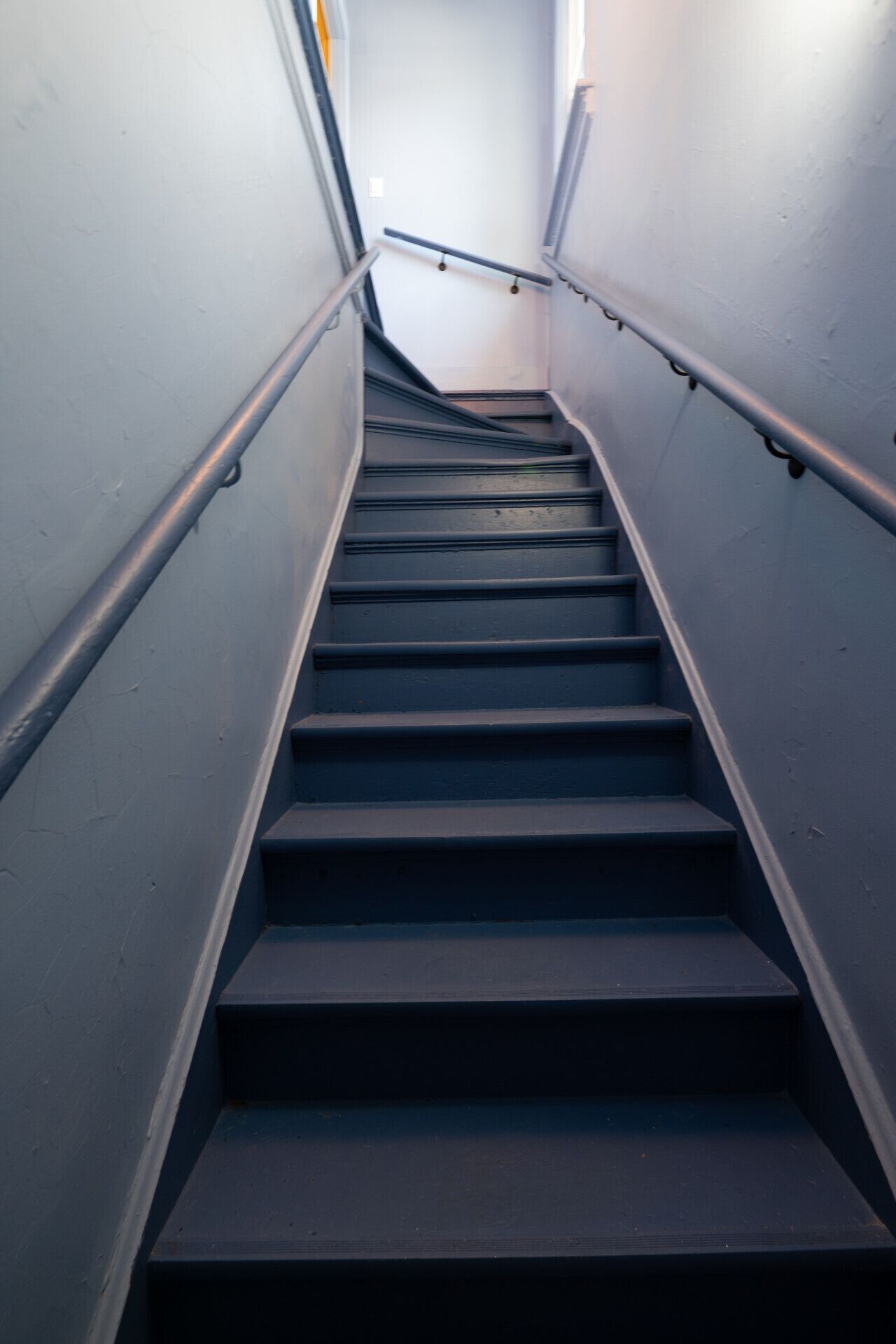 Eine Treppe mit Metallgeländern und einem Geländer auf der rechten Seite.