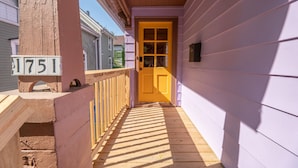 A wooden porch with a yellow door, a mailbox, and a house number sign. - Entire Designer Building, Sleeps 13 (Milwaukee)