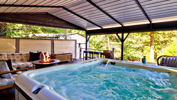 Area idromassaggio con camino, posti a sedere e patio coperto.