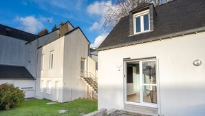 A modern two-story house with a white exterior, a visible staircase leading to the upper floor, and a large glass door entrance. - Au Bonheur Du Voyageur - Proche gare routière (Vannes)