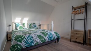 A bedroom with a bed, a nightstand, a dresser, and a wooden ladder. - Au Bonheur Du Voyageur - Proche gare routière (Vannes)