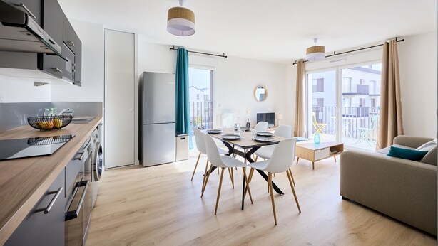 Een moderne keuken met een eethoek, een bank en uitzicht op buiten.