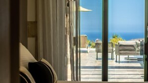 A room with a bed, a view of the sea, and outdoor seating with umbrellas. - Villa Resi, Vamos, Private Pool, Sea View-5 minutes to the beach! (Chania)
