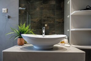A bathroom with a large, white, bowl-shaped sink on a marble countertop, a potted plant, and a glass shower enclosure. - Villa Resi, Vamos, Private Pool, Sea View-5 minutes to the beach! (Chania)
