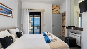 A hotel room with a bed, towels, a TV, a heater, and a view of the sea. - Villa Resi, Vamos, Private Pool, Sea View-5 minutes to the beach! (Chania)