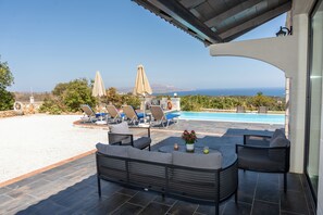 A patio with outdoor seating, a pool, and a view of the ocean. - Villa Resi, Vamos, Private Pool, Sea View-5 minutes to the beach! (Chania)
