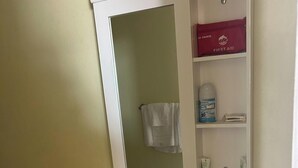 Um banheiro com pia branca, vaso sanitário e armário de remédios sobre a pia.