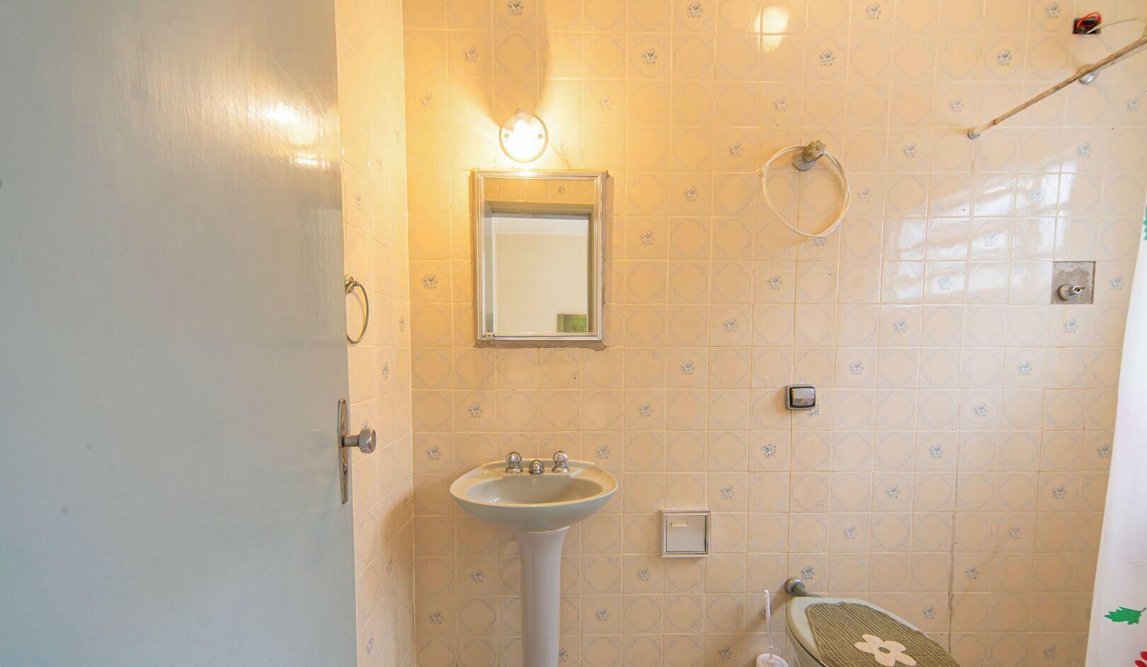 A bathroom with a sink, mirror, towel rack, and toilet.