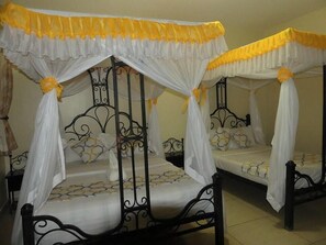 A room with two beds, each with a canopy bed frame and white bedding. - Northern Galaxy Hotel Isiolo (Isiolo)