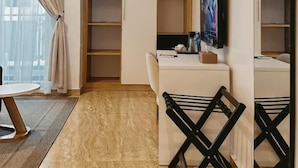 A modern room with a marble floor, a white desk, a black chair, a TV, and a large mirror. - Mayhill Signature (Lekki)