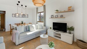 A modern living room with a sofa, TV, and decorative items.
