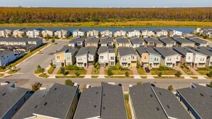 Een woonwijk met rijen herenhuisachtige woningen, een parkeerplaats en een waterpartij op de achtergrond.