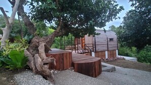 A rustic wooden cabin with a wooden deck and a staircase leading to the entrance. - Siquijor Summit Resort (Lazi)