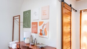 A room with a wooden desk, a mirror, and wall art including a 'Let's Stay Home' sign. - Siquijor Summit Resort (Lazi)