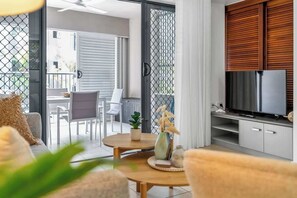 Un salon moderne doté d’un téléviseur, d’un coin repas et d’un balcon offrant une vue agréable.