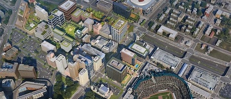 Ein Luftbild einer Stadt mit modernen Gebäuden, einem Stadion und einer großen Menschenmenge.