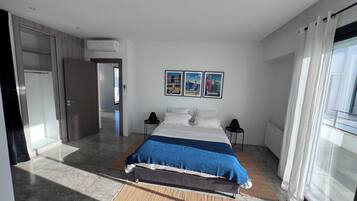 Una habitación de hotel moderna con una cama grande, un televisor de pantalla plana y obras de arte que representan ciudades.