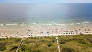 A beach with a wooden boardwalk leading to the shore, sandy beach, and ocean. - Renovated Ocean Front Dream House in Sunset Beach (Sunset Beach)
