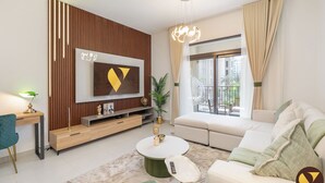 A modern living room with a flat-screen TV, a sofa, a coffee table, and a plant. - Vogue | Jadeel Madinat Jumeirah near Burj Al Arab (Dubai)