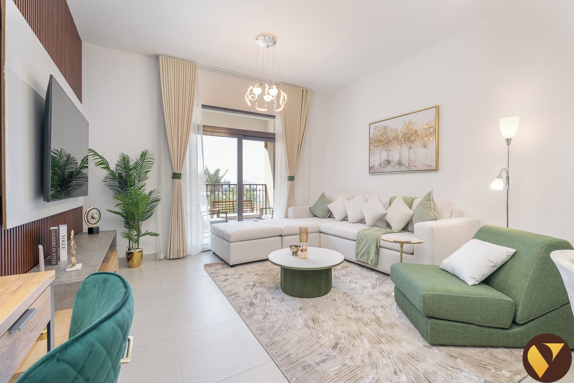 A modern living room with a sectional sofa, a green armchair, a coffee table, and a TV mounted on the wall.