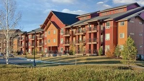 A multi-story residential building with balconies, a parking area, and a landscaped front yard. - Spacious  2-bedroom condo in beautiful Steamboat Springs  CO. (Steamboat Springs)