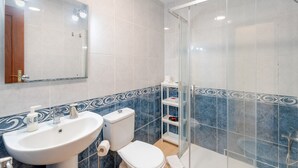Un baño con lavabo, inodoro y cabina de ducha de cristal.