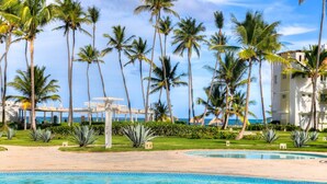 A resort with a pool, palm trees, and a view of the ocean. - Private Beach | Terrace and Pool • Fast WiFi (Punta Cana)