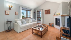 Ein Wohnzimmer mit Sofa, Couchtisch, Kamin und Bildern an den Wänden.