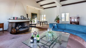 A spacious living room with a fireplace, a blue sofa, and a glass coffee table. - Saint Peter's Luxury Terrace Suites (Roma)