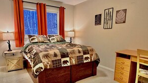 A bedroom with a bed, nightstands, a desk, and artwork on the wall. - Nordic Retreat with private Finnish Sauna (Anchorage)