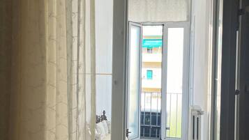 Ein Gang, der zu einem Balkon mit Blick auf ein Gebäude führt.
