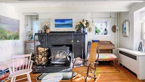 Una sala de estar acogedora con chimenea, muebles de madera y vistas al exterior.
