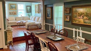 A dining area with a wooden table set for six, surrounded by wooden chairs. - Unique Luxury Central Historic Landmark Home (Lambertville)